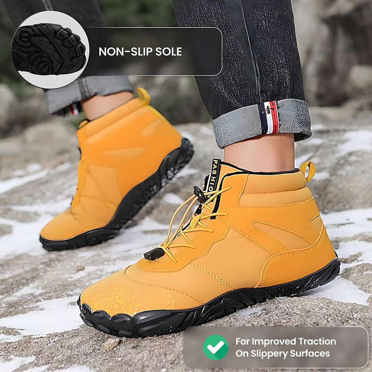 Yellow Vindra Flex barefoot boots worn on snowy rocks, non-slip sole inset for traction on slippery surfaces